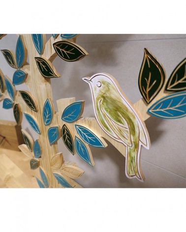 Un oiseau peint sur du bois à la main par une artiste peintre qui a collaboré à la création de ce très grand Arbre de Vie !